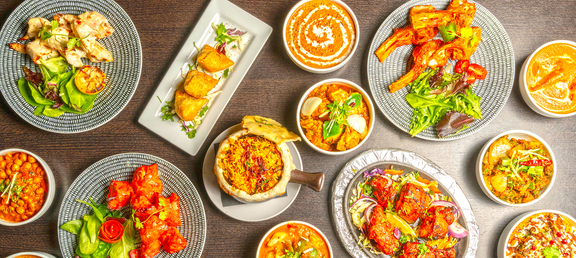 Overhead table of Bombay Grove curries, tandoori platters, samosas and biryani