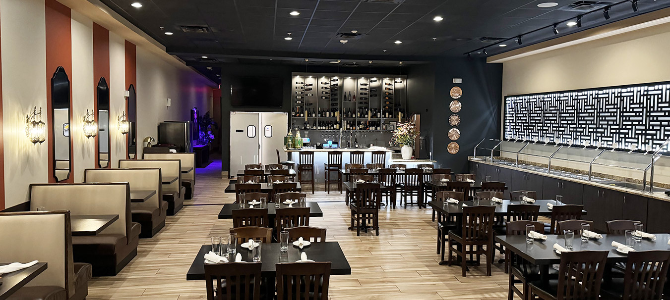 Wide view of the Bombay Grove dining room with booths, the full bar and the buffet line