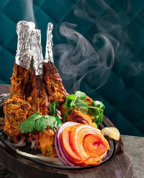 Tandoori lamb chops served smoking on a cast iron platter