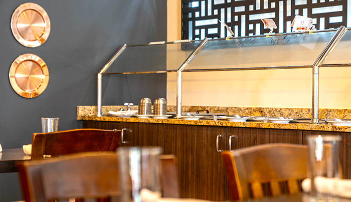 Granite buffet counter and copper wall discs at Bombay Grove