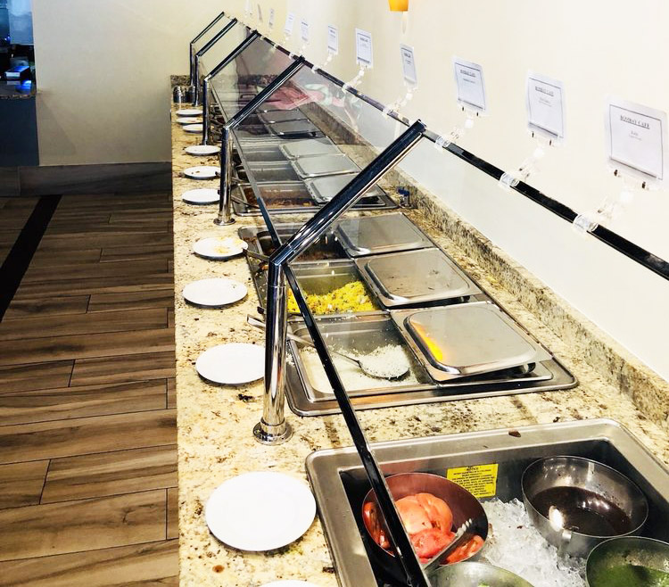 The Bombay Grove lunch buffet line with labelled warming trays and stacked plates