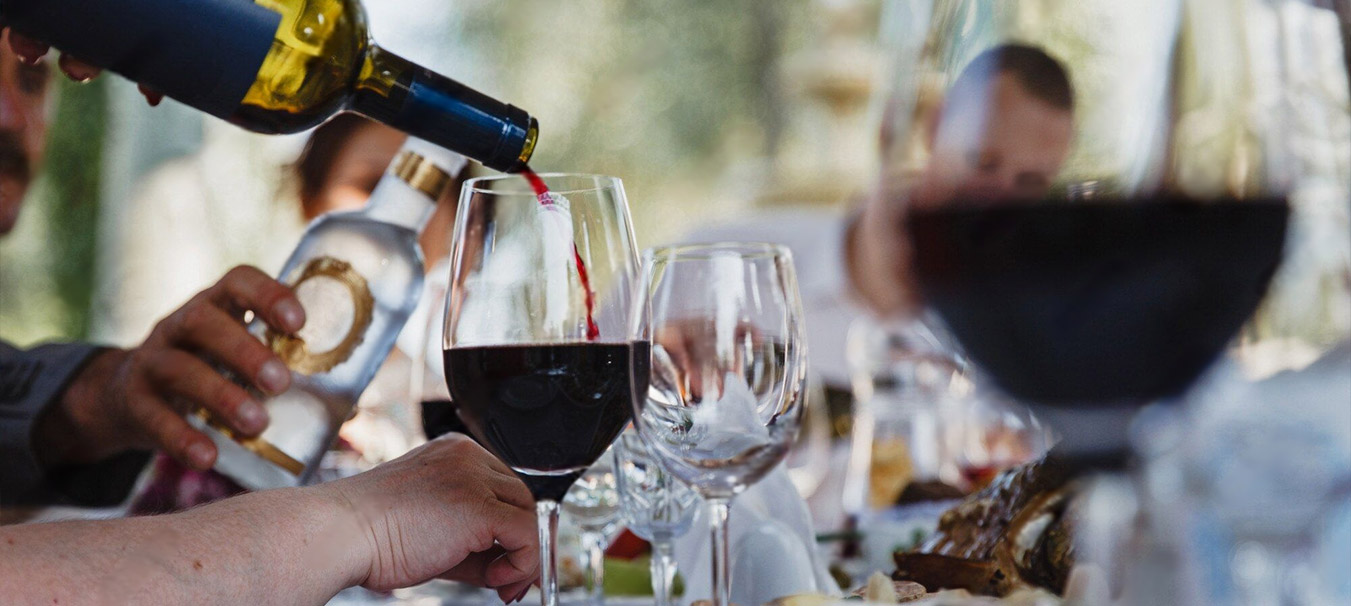 Red wine poured at a table during dinner at Bombay Grove