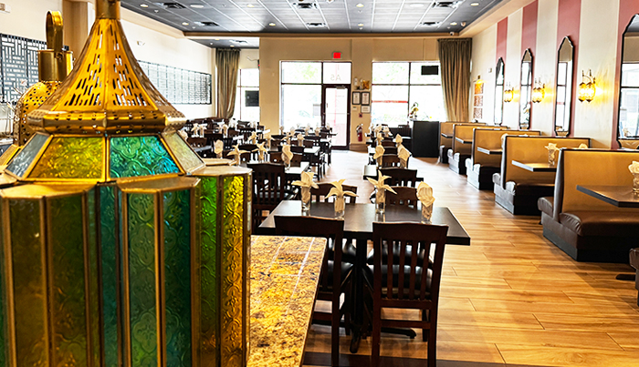 Stained glass lantern in the foreground of the Bombay Grove dining room and booths