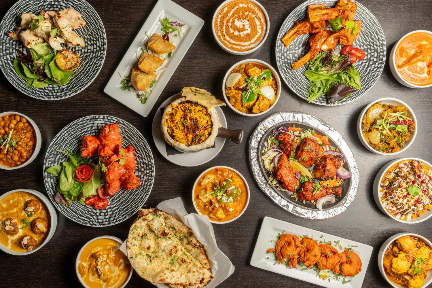 Overhead spread of Bombay Grove dishes — tandoori, curries, biryani and fresh naan