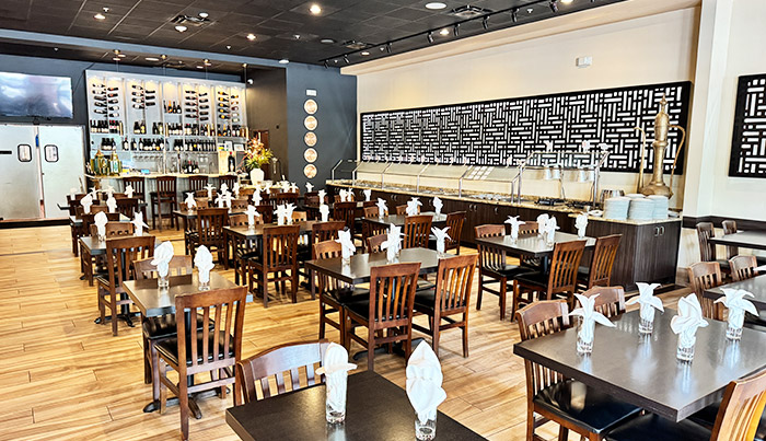 Set tables in front of the laser-cut screen wall and buffet counter at Bombay Grove